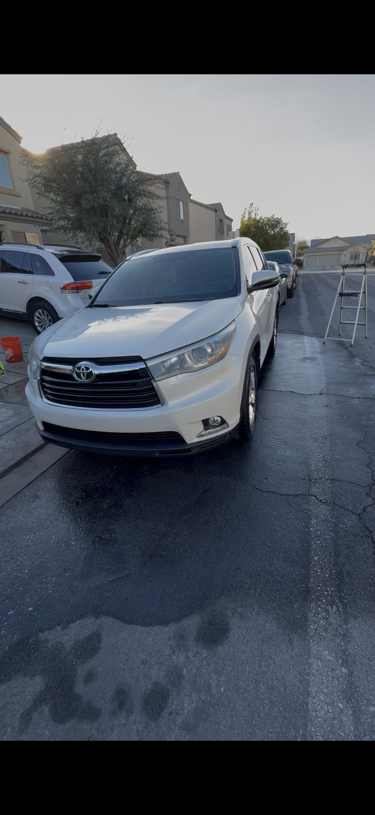 White Toyota Highlander freshly washed on a wet driveway